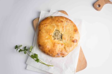 Beyaz arkaplanda servis edilen etli khachapuri turtası.