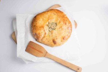 Beyaz arkaplanda servis edilen etli khachapuri turtası.