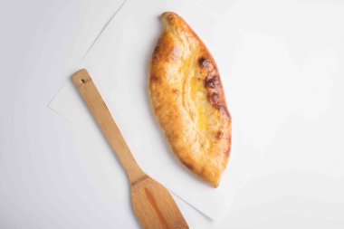 Kapalı Khachapuri turtası beyaz arka planda bir tahtada servis edilir