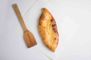 Kapalı Khachapuri turtası beyaz arka planda bir tahtada servis edilir