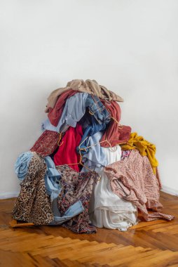 İkinci el kıyafetlerle dolu. Sürdürülebilir moda kavramı. Hafif arka planda kullanılmış giysiler yığını. Geri dönüşüm için ikinci el