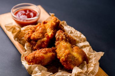 Kızarmış tavuk kanadı ve ketçap.