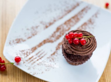 Beyaz servis tabağında kırmızı üzümlü klasik kekler.