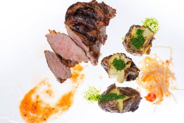 Şeffaf bir masada sulu biftek ve sebze. 