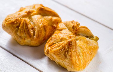 Beyaz arka planda taze hamur işleri. Beyaz arkaplanı dolduran birkaç rulo