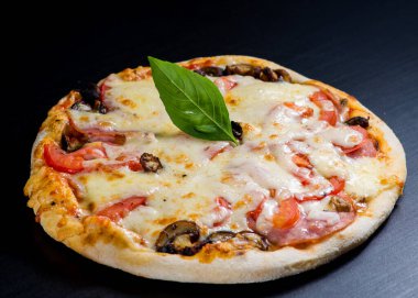 Siyah arka planda taze İtalyan pizzası.