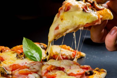 Pizza bir dilim kes. Eritilmiş peynir uzanıyor parçasındaki