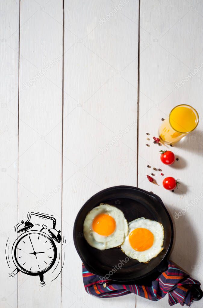 breakfast of fried eggs and juice on a white table