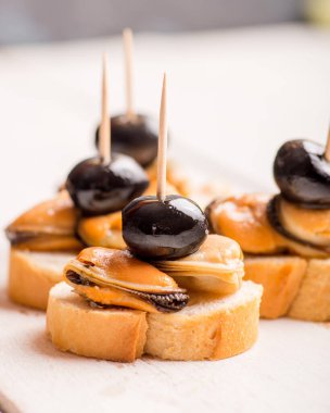 Hafif bir zemin üzerinde beyaz şarap için aperatif olarak midye ve zeytin