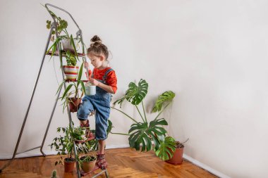 Kot pantolonlu çocuk sulandırıcı bardaktan su içiyor.