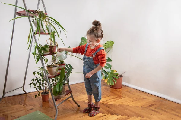 Kot pantolonlu çocuk sulandırıcı bardaktan su içiyor.