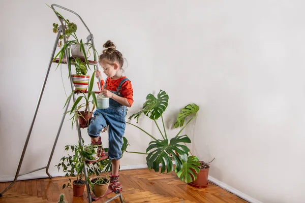 Kot pantolonlu çocuk sulandırıcı bardaktan su içiyor.