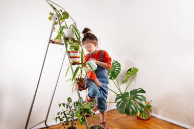 Kot pantolonlu çocuk sulandırıcı bardaktan su içiyor.