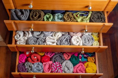 Dikey depolanmış bükümlü giysileri olan göğüs çekmecelerini aç. Yukarıdan bak. Dolapta giysi deposu var. Japon yöntemi