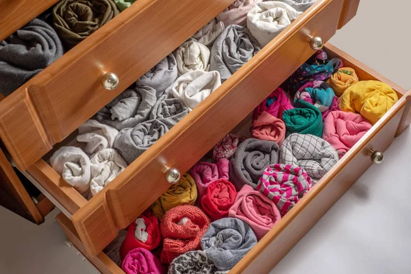 Open chest drawers with  vertical storaged twisting clothes. View from above. Storage of clothes in the wardrobe. Japanese method