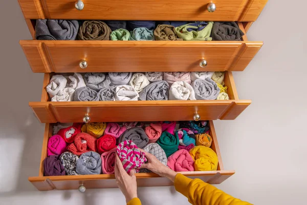 Giysileri Japon tarzında temizleme ve sıralama. Dikey depolanmış bükümlü giysileri olan göğüs çekmecelerini aç. Yukarıdan görüntüle. 