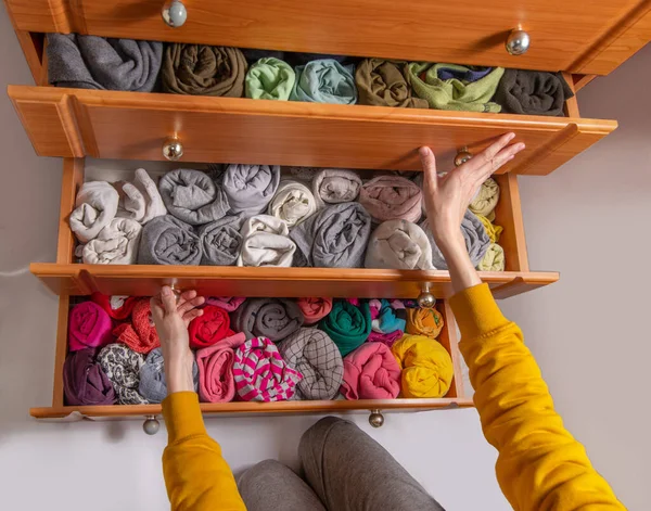 Giysileri Japon tarzında temizleme ve sıralama. Dikey depolanmış bükümlü giysileri olan göğüs çekmecelerini aç. Yukarıdan görüntüle.