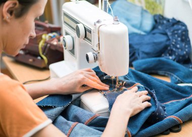 Sustainable living and fashion. A woman is sewing second-hand. Waste-free living and reuse