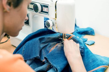 Sürdürülebilir yaşam ve moda. Bir kadın ikinci el dikiş dikiyor. Atık içermeyen yaşam ve yeniden kullanım