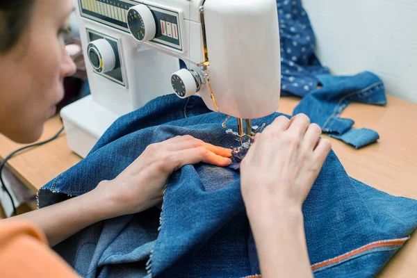 Sustainable living and fashion. A woman is sewing second-hand. Waste-free living and reuse