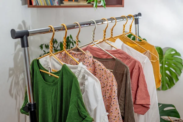 Second-hand clothes  on the rail. The concept of sustainable economic life. Sale of clothes. Summer women\'s clothing on the swap. Clothing store