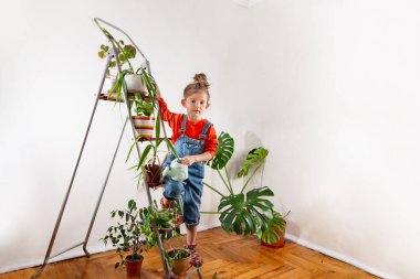 Kot pantolonlu çocuk sulandırıcı bardaktan su içiyor.