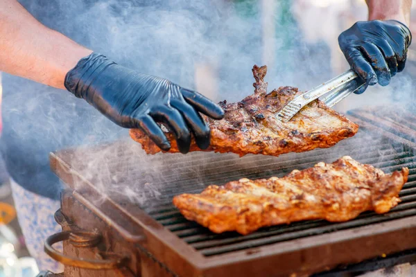 烧烤排骨 戴手套的人在炭烤架上烤排骨 全家度假的时候 在后院野餐 烧烤肉 — 图库照片