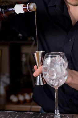 Barmen bir kokteyl dolduruyor.