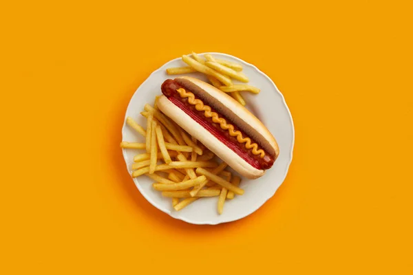 Cachorro-quente tradicional com batatas fritas em prato no fundo laranja. Menu restaurante — Fotografia de Stock