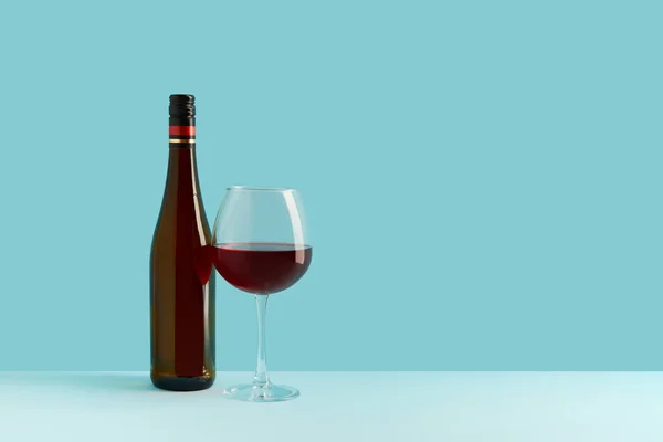 Palack és pohár vörösbor kék háttérrel. Mock up ital helyet az Ön számára lable és szöveges — Stock Fotó