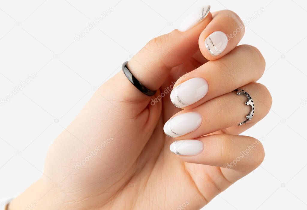 Beautiful groomed womans hand with modern french nail design on white background. Manicure pedicure beauty salon concept