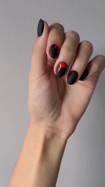 Vídeo vertical con la mano de las mujeres con la manicura de Halloween de moda sobre fondo gris. Tendencias de diseño de uñas. — Vídeo de stock