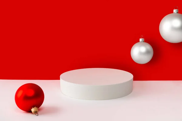 Pódium s vánoční ozdoby na červeném a bílém kreativním pozadí. Vyhonit šablonu pro zobrazení produktu. — Stock fotografie
