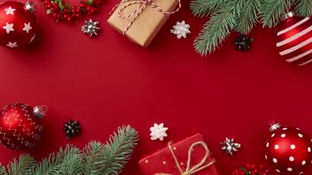 Stop mozgás animáció karácsonyi újévi ajándék dobozok, díszek, karácsonyfa ágak mozog a piros asztalon — Stock videók