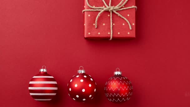 Stop-Motion-Animation mit Weihnachts-Geschenkboxen, Ornamenten, Weihnachtsbaumzweigen bewegt sich auf rotem Tisch — Stockvideo