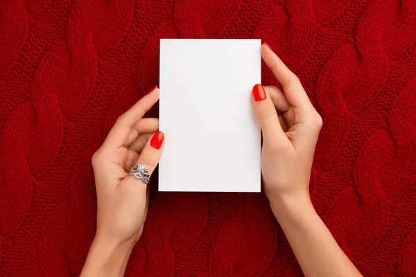 Χειροποίητα γυναικεία χέρια που κρατούν κάρτα Greekeng σε πλεκτό μάλλινο κόκκινο ύφασμα — Φωτογραφία Αρχείου