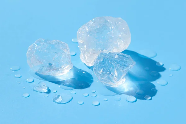 Close up crushed melting ice in sunlight on blue background — Stock Photo, Image