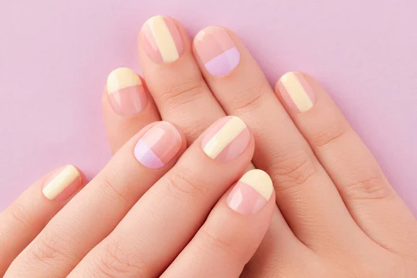 Prachtige wijfjes handen met manicure op lila achtergrond. Trendy minimale lente zomer nagel ontwerp — Stockfoto