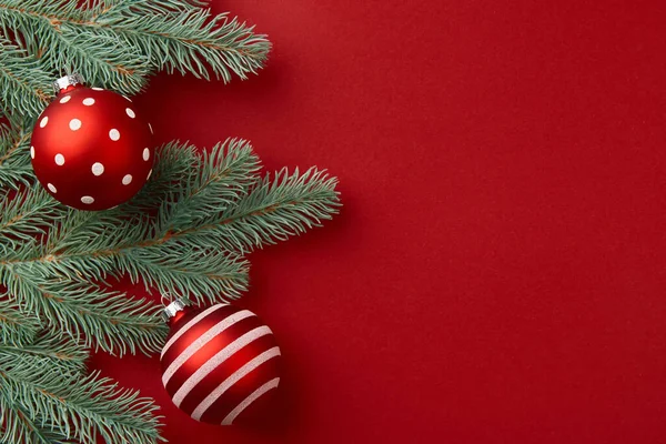 Composición navideña. Ramas y ornamentos del árbol de Navidad sobre fondo rojo — Foto de Stock