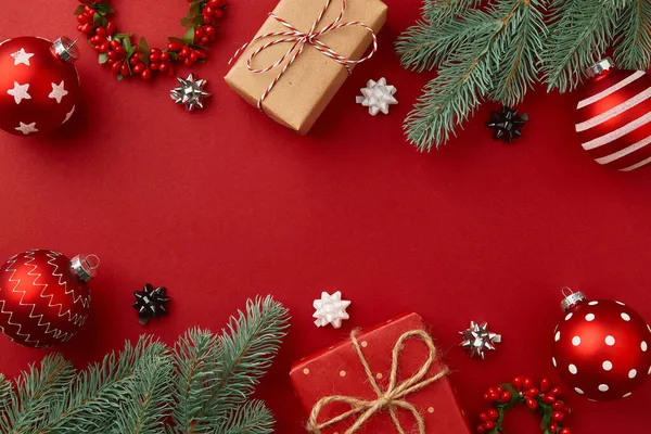 Composición navideña. Regalos ramas de árbol de Navidad y adornos sobre fondo rojo — Foto de Stock