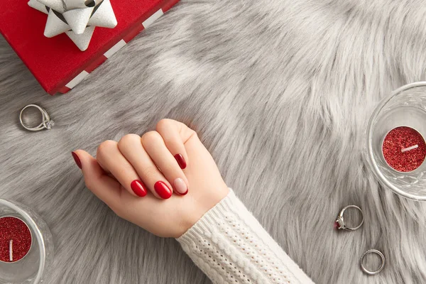 Mano femenina con diseño de uñas Día de San Valentín de Navidad sobre fondo gris. Manicura, concepto de salón de belleza pedicura. — Foto de Stock