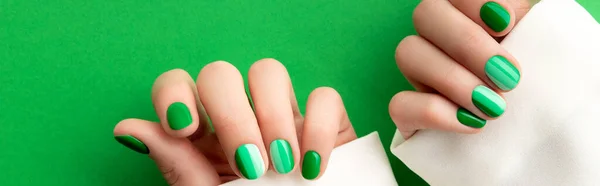 Schöne gepflegte Frauenhände mit Frühling Sommer Nageldesign auf grünem Hintergrund. — Stockfoto
