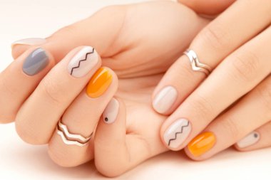 Manicured womans hands close up on beige background. Minimal spring autumn nail design clipart
