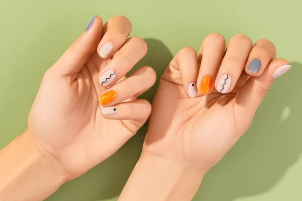 Cerca de las manos de las mujeres con manicura mínima de moda sobre fondo verde. Primavera verano diseño de uñas —  Fotos de Stock