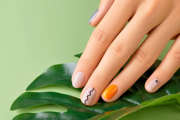 Mooie vrouwen hand met minimale nagel ontwerp op groene achtergrond. Manicure, pedicure schoonheidssalon concept — Stockfoto