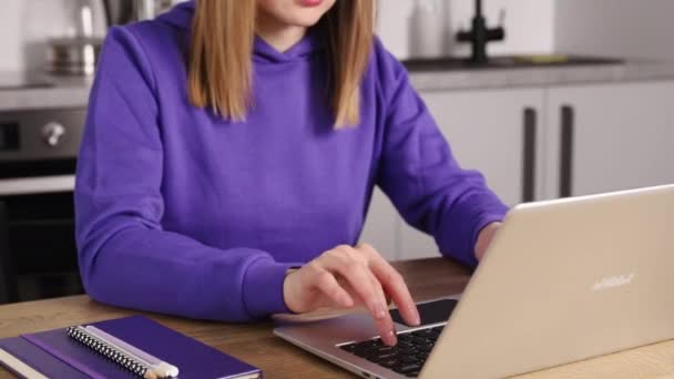 Mladá dospělá žena ve fialové mikině na notebooku. Práce z konceptu domova — Stock video