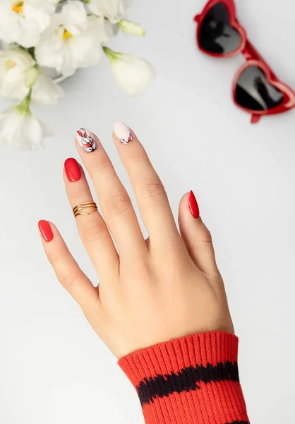 Piękne młode kobiety ręka z czerwonym manicure na szarym tle — Zdjęcie stockowe