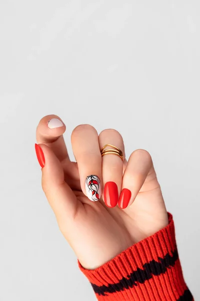 Mooie jonge vrouwen hand met rode manicure op grijze achtergrond — Stockfoto