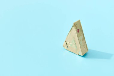 Uzun gölgeli mavi arka planda işlenmiş peynir. Asgari yaratıcı gıda konsepti