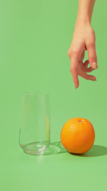 Остановите анимацию с крупным планом женской руки, сжимающей апельсин. Человек, давящий сочные фрукты без соковыжималки — стоковое видео